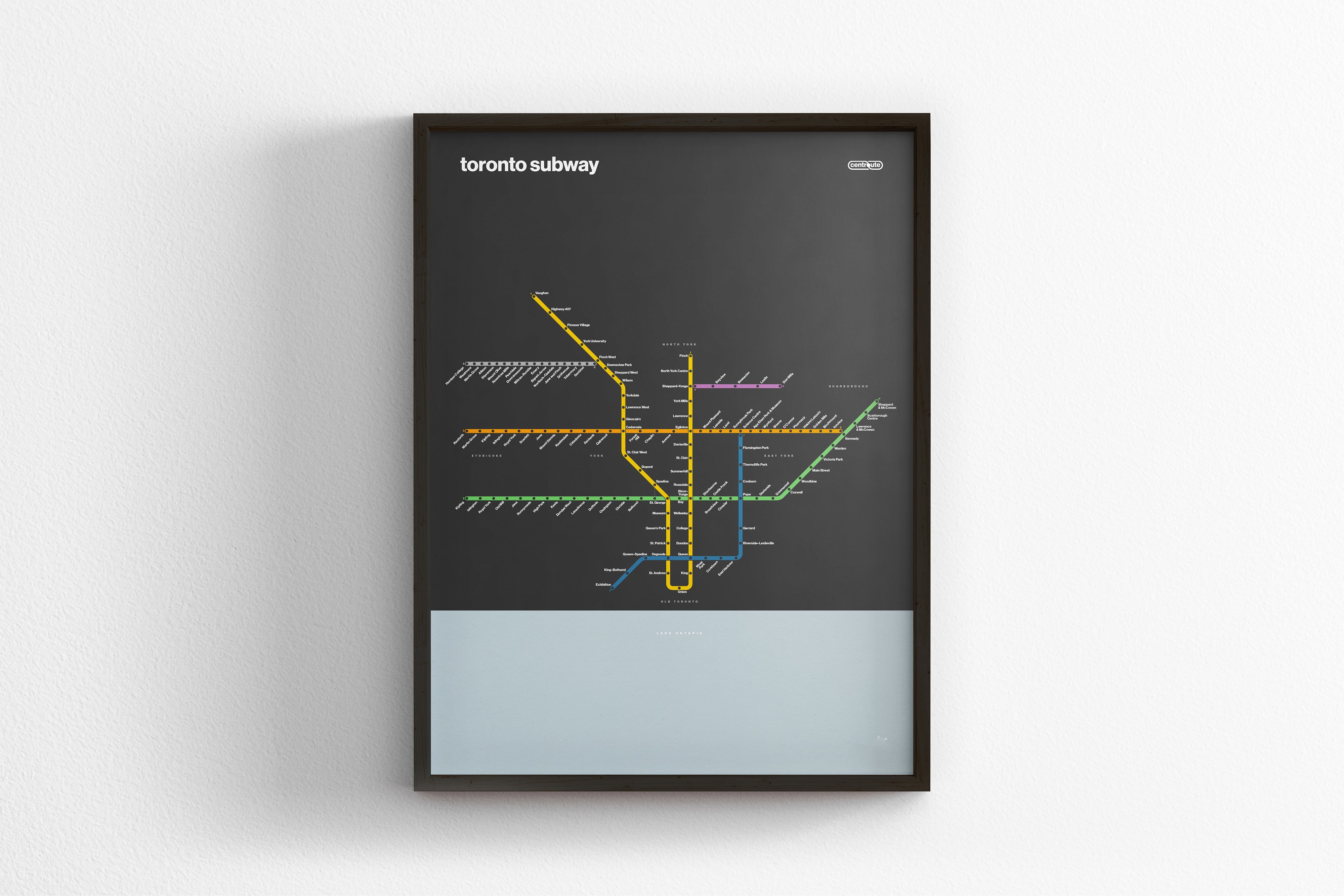 A framed subway map of Toronto, Canada, with various colored lines representing different routes and stations.