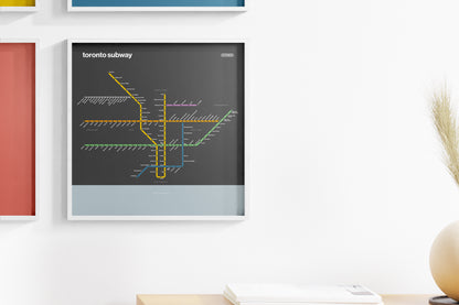 a framed subway map of Toronto, Canada, hanging on a wall.