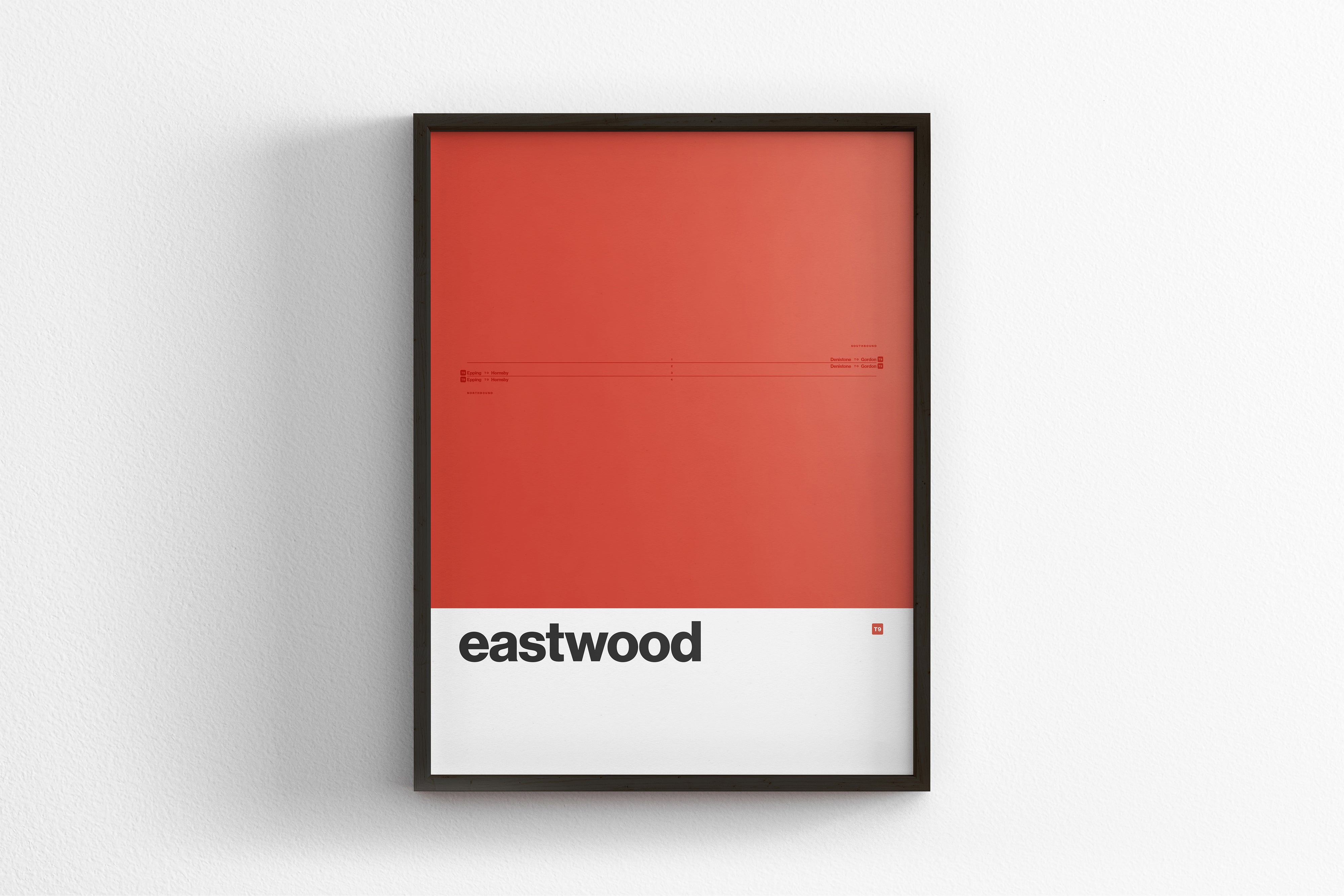 A framed poster with a red background and the word "eastwood" written in black text.