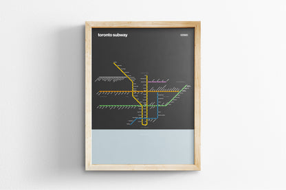 A framed subway map of Toronto, Canada, with various colored lines representing different routes and stations.